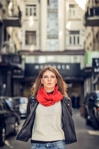 Modellen är på en sida gatan och titta på kameran. Kvinnan på vinden blåser. — Stockfoto