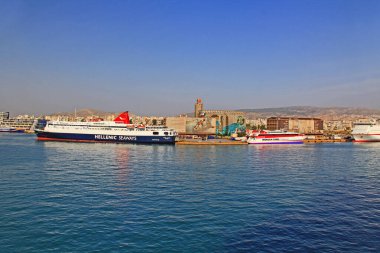 Pire Limanı, Atina, Attica, Yunanistan, 18 Ekim 2018: Feribot tekneli Pire Limanı ve arka planda şehir ve dağların manzarası ve mavi gökyüzü alanı.
