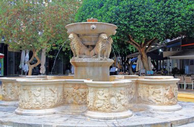 Kallergon Meydanı 'ndaki Aslan Çeşmesi' ni ya da Girit, Yunanistan 'daki Lions Meydanı' nı süsleyin. Ağzından su fışkıran dört aslanlı Venedik çeşmesi açık bir kafenin yanında.. 