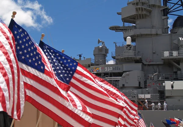 Drapeaux américains volant à côté du Battleship Missouri Memorial, avec quatre marins — Photo