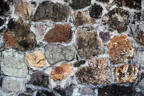 Mur texturé de fond avec des pierres inhabituelles de différentes couleurs, formes, textures et tailles trouvées à Antigua Barbuda dans les Caraïbes Petites Antilles Antilles . — Photo