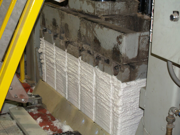 A cotton bale being built in the cotton bale press.