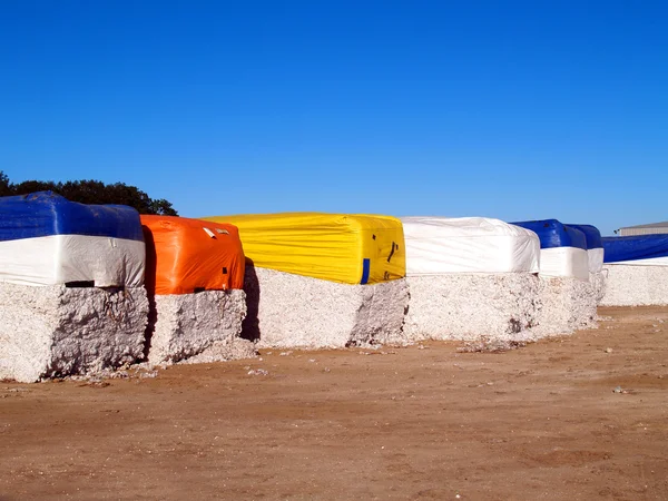 Colorful cotton modules lined up in a cotton gin lot in south Georgia. — Stock Photo, Image