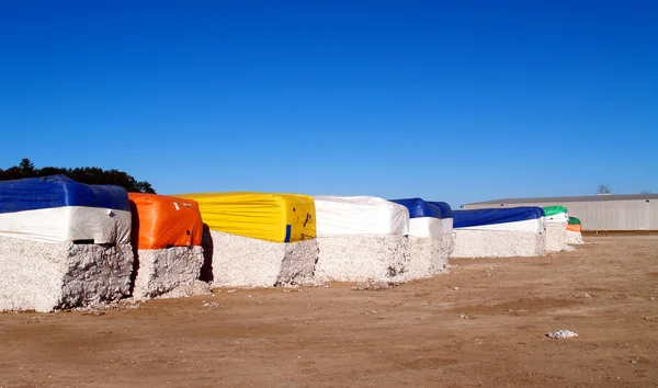 Colorful cotton modules lined up in a cotton gin lot in south Georgia. — Stock Photo, Image