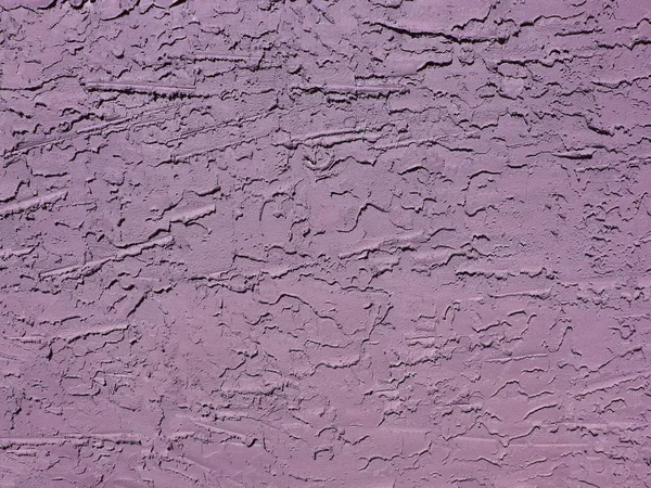 Rough textured concrete or stucco exterior wall painted lavender.