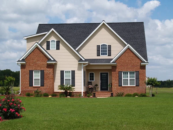 Two story residential home with both brick and board siding on the facade. — Stock Photo, Image