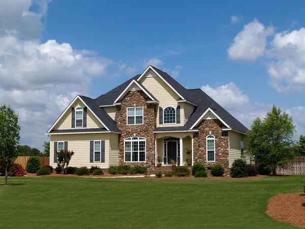 Twee verhaal huis met zowel steen en board siding op de gevel. — Stockfoto