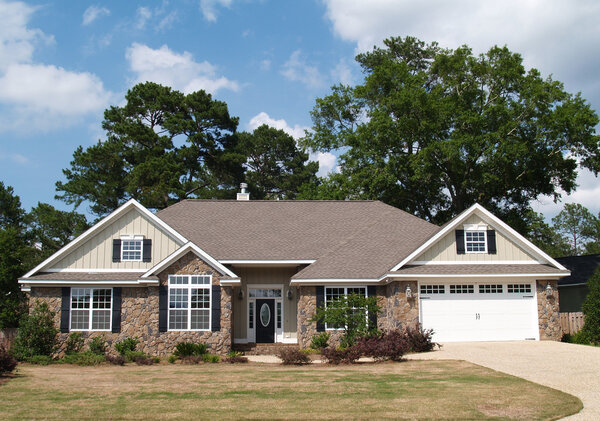 One story residential home with both stone and board siding on the facade.