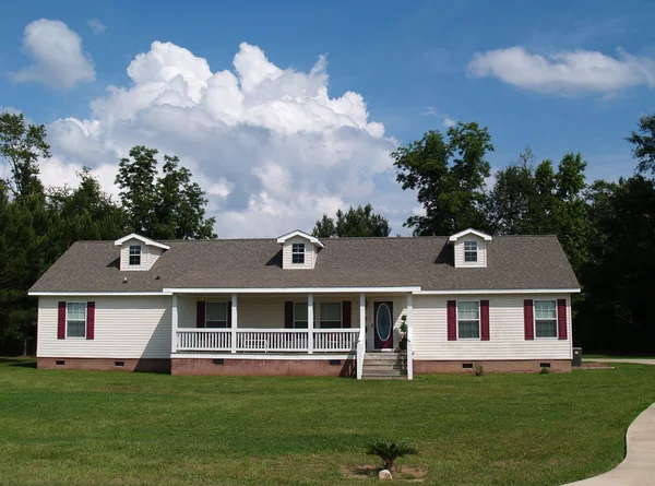 One story residential home with vinyl siding on the facade and a brick foundation. — Stock Photo, Image