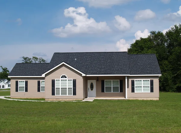 Een verhaal residentieel laag inkomen huis met vinyl opruimen op de gevel. — Stockfoto