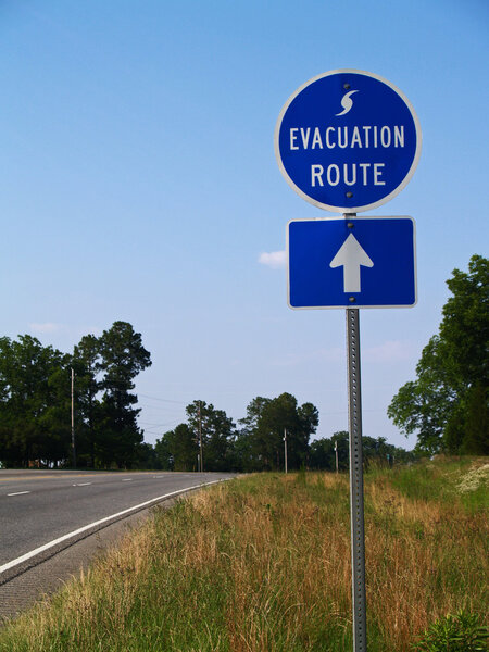 Blue hurricane evacuation route sign along a highway.