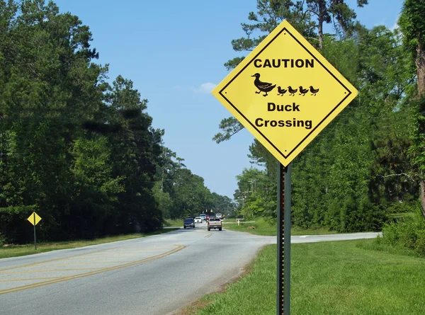 Amarelo diamante cautela pato sinal de travessia ao lado de uma estrada . — Fotografia de Stock