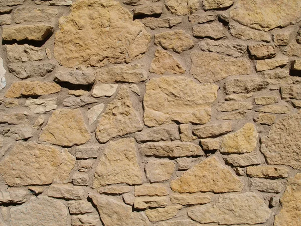 Tan gekleurde muur met multi formaat platte gelaagde stenen — Stockfoto