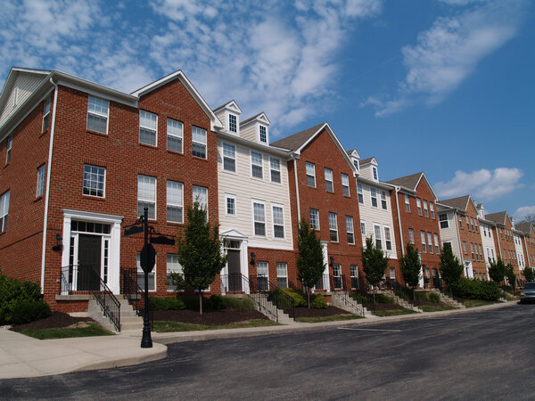 A row of brick condos or townhouses beside a street.
