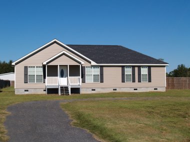 Small low income manufactured home with a covered porch and vinyl siding. clipart