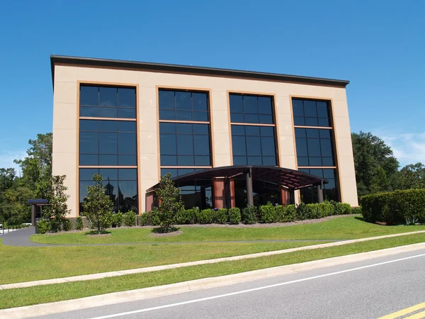 Üç katlı ofis binası ile çoğunlukla cam ön ve tente üzerinde açık yürüyüş.