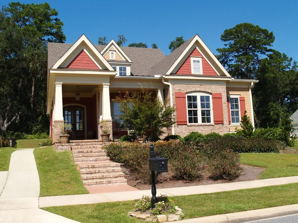 Beige brick home having peach and white trim with steps leading up to squares columns on the porch. — Stock Photo, Image