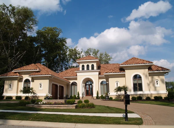 Un piano stucco casa residenziale con un tetto di argilla rossa e garage laterale . — Foto Stock