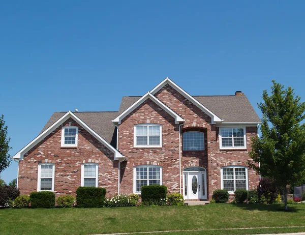 Two story new brick residential home with side garage and plenty of copy space. — Stock Photo, Image