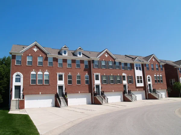 Rode bakstenen appartementen of herenhuizen met de garage aan de voorkant. — Stockfoto