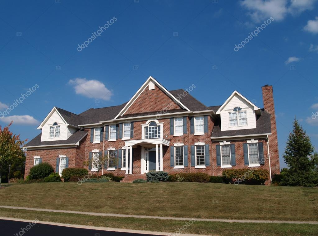 Large Two Story Brick Residential Home With Blue Shutters And