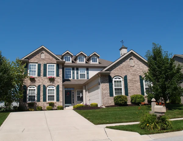 Two story brick home with window boxes and garage. — Stock Photo, Image