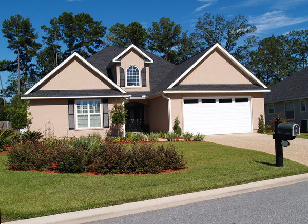 One story residential low-income home with board or vinyl siding and front entry garage.