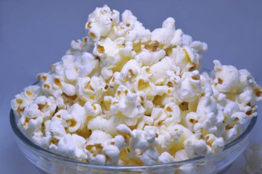 Şeffaf bir kasede bir araya getirilmiş izole patlamış mısırlar.