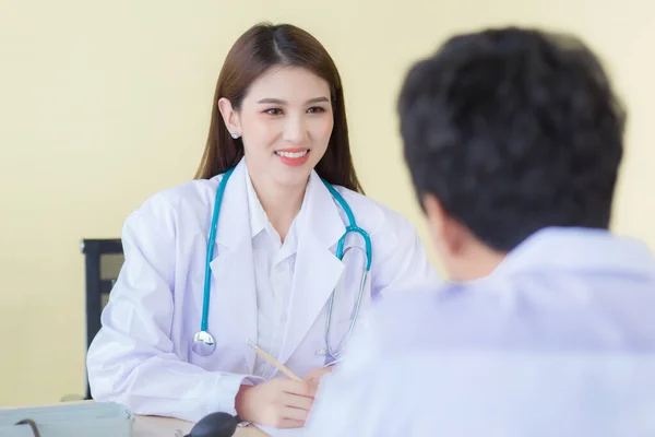 一位美丽的亚洲女医生笑着询问她的症状 穿着白色长袍和听诊器呆在医院里 Coronavirus保护概念 — 图库照片