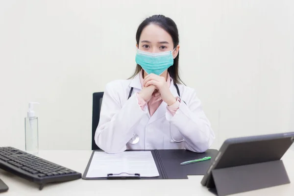 アジアの女性医師マスクを着用し 熟考試験室に座って — ストック写真