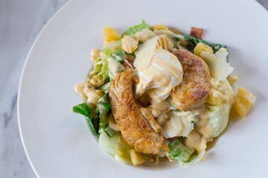 Taze yeşil sebzeli Sezar salatası ızgara beyaz yumurta ve çıtır ekmekle karıştırılır. Sağlıklı bir yiyecek konsepti..