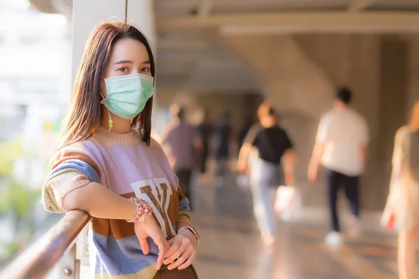 身穿五颜六色毛衣的亚洲妇女戴着医疗面罩 这是一种新的普通保健观念 — 图库照片