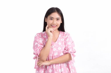 Pembe elbiseli ve siyah uzun saçlı Asyalı güzel bayan. Elleri yanağa dokunur, gülümser, beyaz arka planda güzel bir ten gösterir..