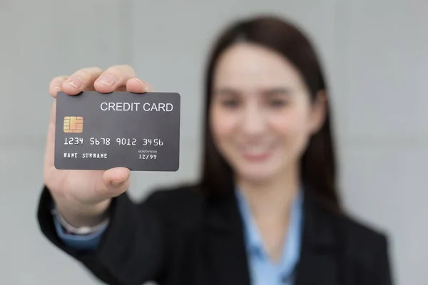Asian business working woman shows credit card closed up in financial choice concept.