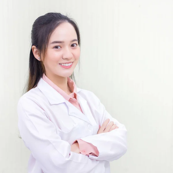 黒い長い髪をしているアジアの女性医師は ヘルスケアの病院のオフィスルームで腕のクロスながら 一様として聴診器と白いラボのコートを身に着けている 新しい通常とコロナウイルス保護の概念 — ストック写真
