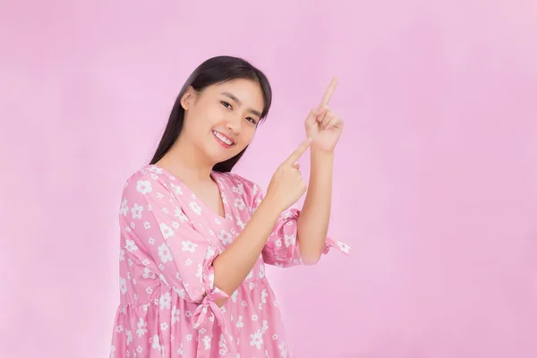 亚洲美丽的女人 一头乌黑的长发 粉红的衬衫 手指着粉红的背景 — 图库照片