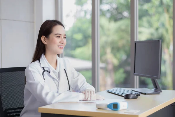 Asiático Profesional Joven Sonriente Mujer Médico Sentado Mirar Hacia Adelante — Foto de Stock