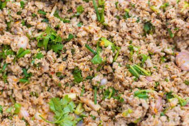 Baharatlı kıymalı domuz salatası Tayland 'ın kuzeydoğusunda geleneksel yemektir. İçinde kıyma, kızarmış pilav, kavrulmuş acı biber ve Tayland bitkisi var..