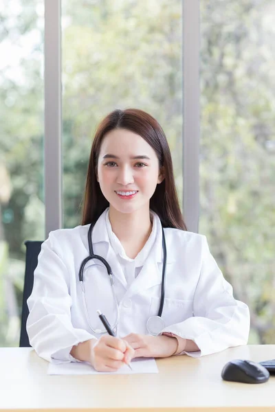 Asian Professional Woman Doctor Writing Something Paper While Sits Works — Stock Photo, Image