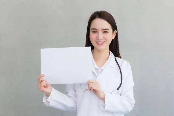 身穿医疗外套的亚洲女医生拿着并展示着白纸来展示某种医疗保健理念 — 图库照片