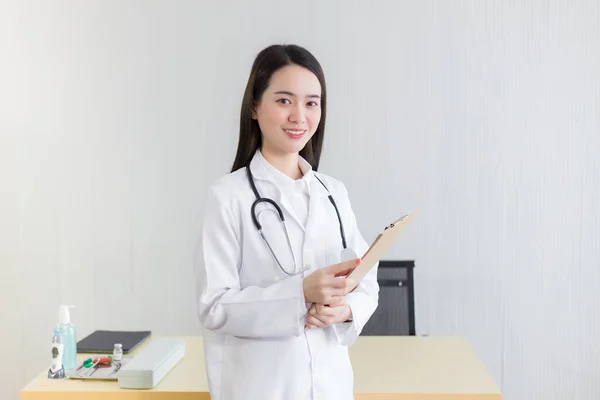 病院で働く若い美しいアジアの女性医師 彼女は白いローブと聴診器を着て クリップボードを手に持っています 健康とコロナウイルスの概念 — ストック写真