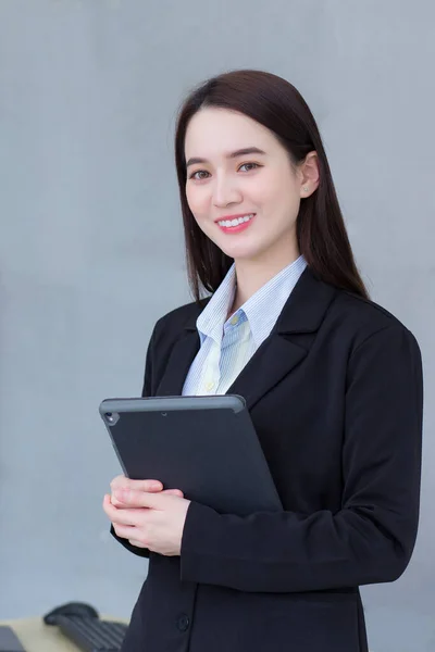 Azjatka Profesjonalna Pracująca Kobieta Czarnym Garniturze Trzyma Tabletkę Dłoniach Uśmiecha — Zdjęcie stockowe