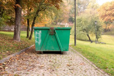 Kesilen çimenleri ve düşen yaprakları toplamak için konteynır. Ev atıkları için büyük metal konteynır. Düşen yaprakları ve otları temizliyorum. Parklara ve meydanlara düzen getiriliyor