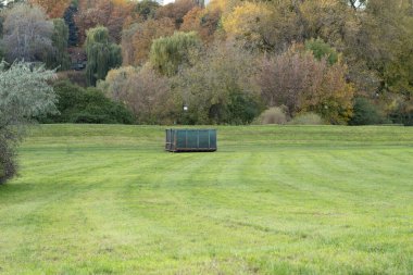 Kesilen çimenleri ve düşen yaprakları toplamak için konteynır. Ev atıkları için büyük metal konteynır. Düşen yaprakları ve otları temizliyorum. Parklara ve meydanlara düzen getiriliyor