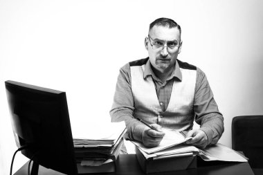 Erkek ofis çalışanı masada kağıtlarla çalışır. İş sırasında ofis çalışanı.