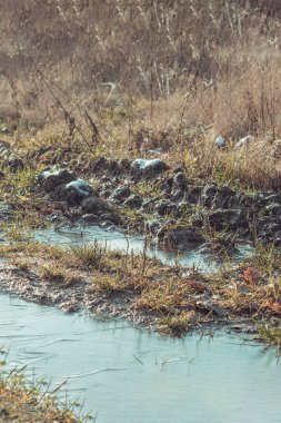 Toprak yolda ilk kar ve don. Donmuş toprak yol ve çimlerin üzerinde kar olan çamur.