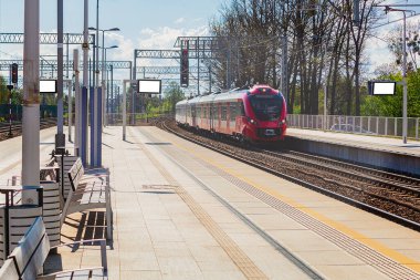 Tren istasyon platformuna varır. Kırmızı trenin lokomotifi platforma ulaşır.