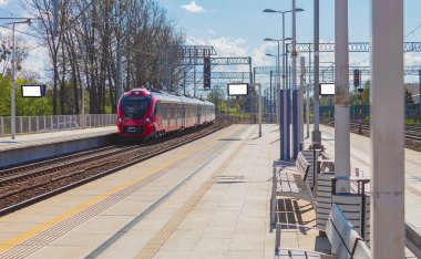 Tren istasyon platformuna varır. Kırmızı trenin lokomotifi platforma ulaşır.