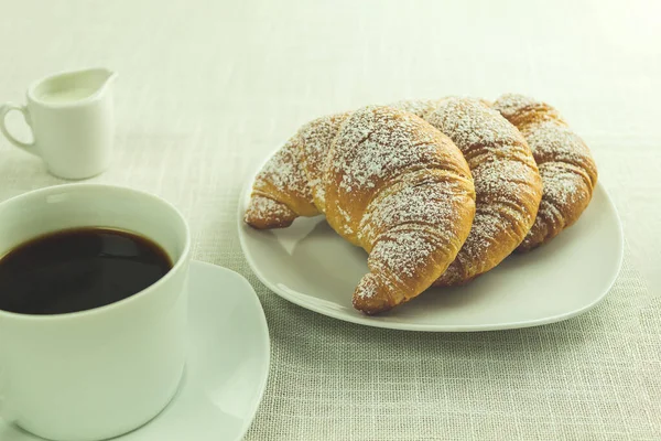 Delicious Croissants and black coffee for breakfast. Copy space for text. Coffee and croissant on white background