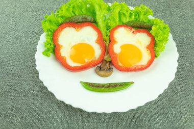 Beyaz tabakta neşeli yüzlü sahanda yumurta. Kahvaltı için beyaz tabakta duygusal çırpılmış yumurta, mesaj için yer. Çocuklar için eğlenceli ve sağlıklı bir kahvaltı.